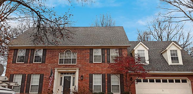 After: Brick colonial home with dormers after roof cleaning in the Little Rock area