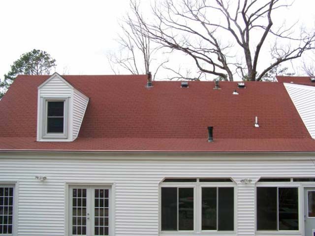 After: Red roof with dormers restored to its original color by roof cleaning near Little Rock AR