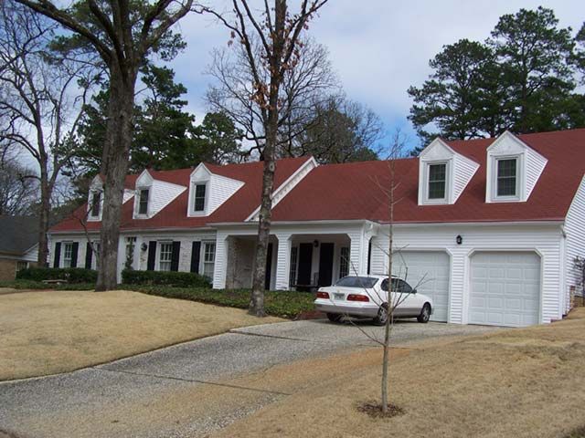 After: Cape Cod home with a red roof soft washed clean in central Arkansas