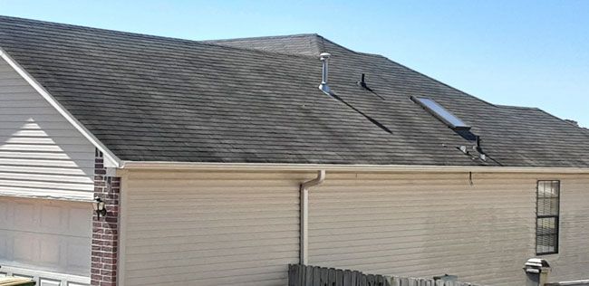 Before: Siding and brick ranch home with a streaked roof cleaned in central Arkansas