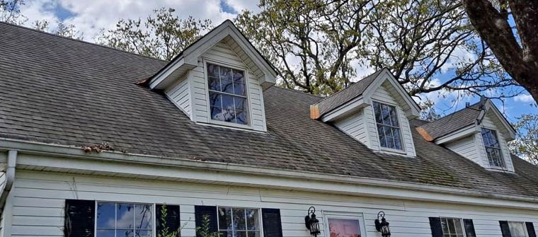 Before: Two-story home with a stained upper roof after roof cleaning in central Arkansas