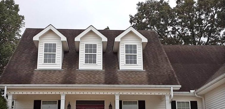 After: Roof with white dormers cleaned of black streaks in central Arkansas
