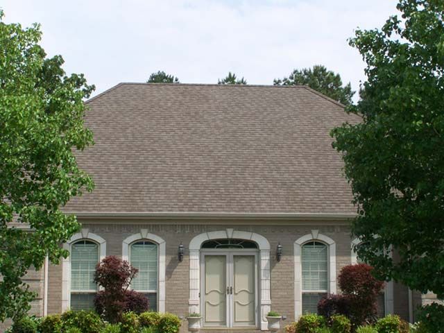 After: Tall gray shingle hip roof on a stucco home after roof cleaning in the Little Rock area
