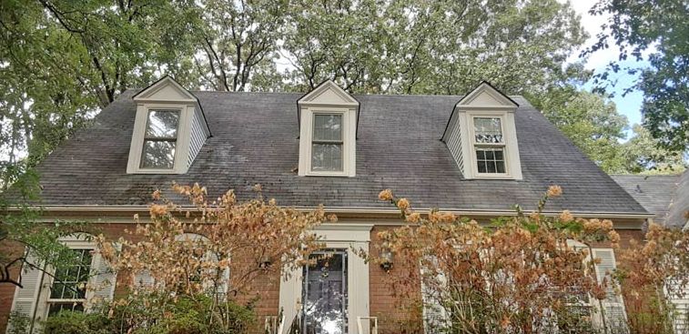 Before: Three-dormer roof with mildew stains soft washed clean in the Little Rock area
